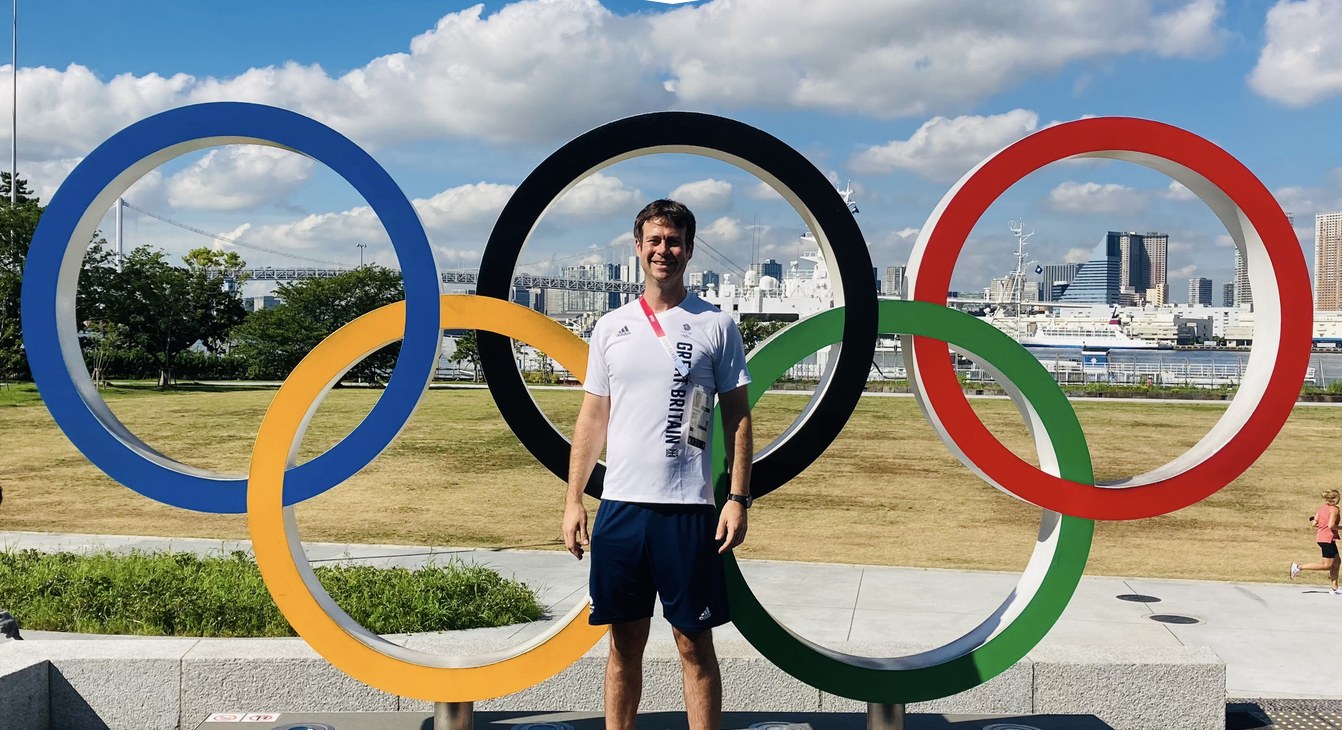 Oli Williamson standing in front of the Olympic rings